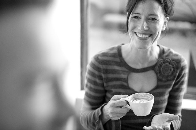 Woman Smiling, Holding A Cup Of Fancy Coffee