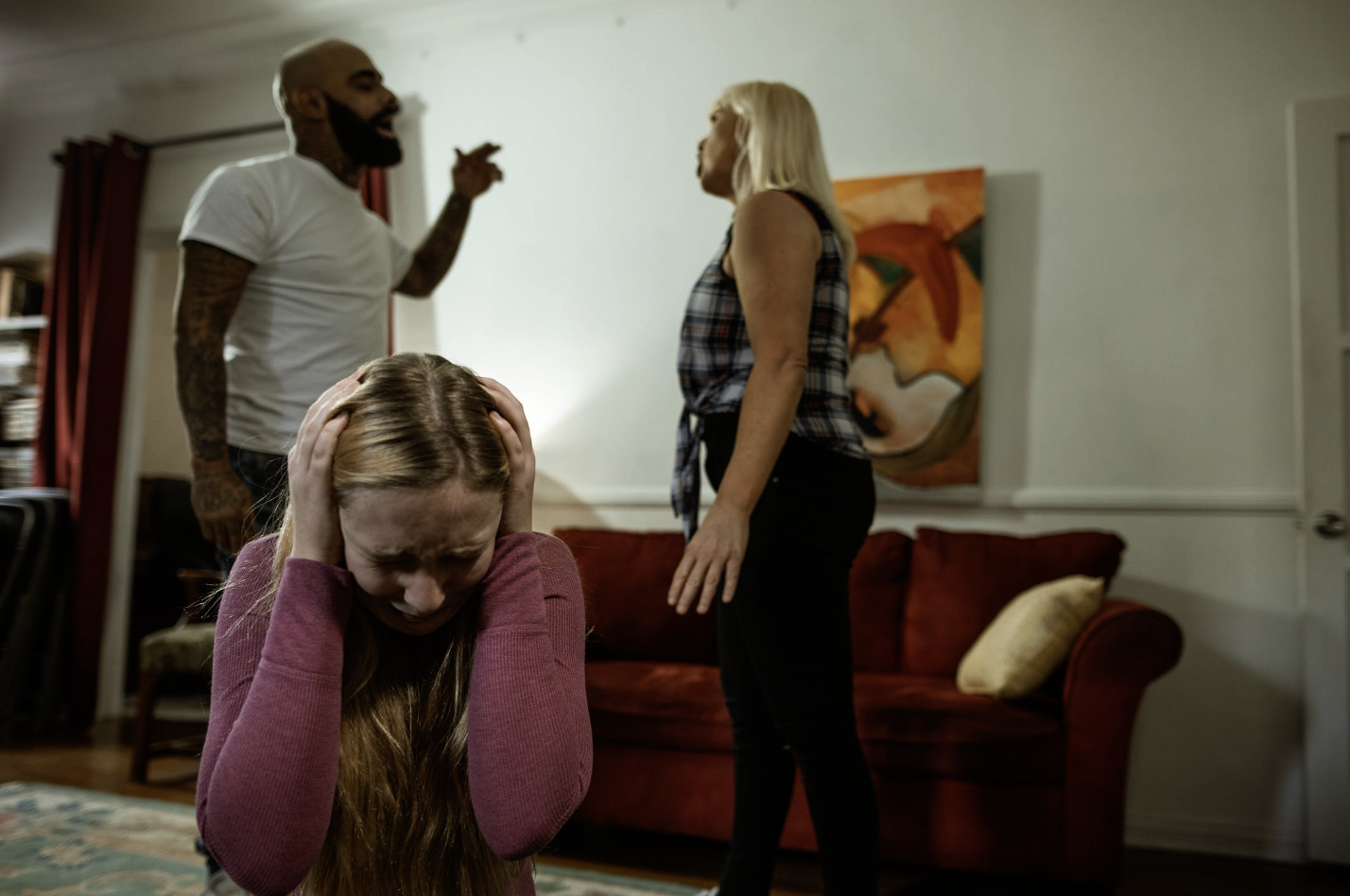 Couple arguing while a family member holds their ears